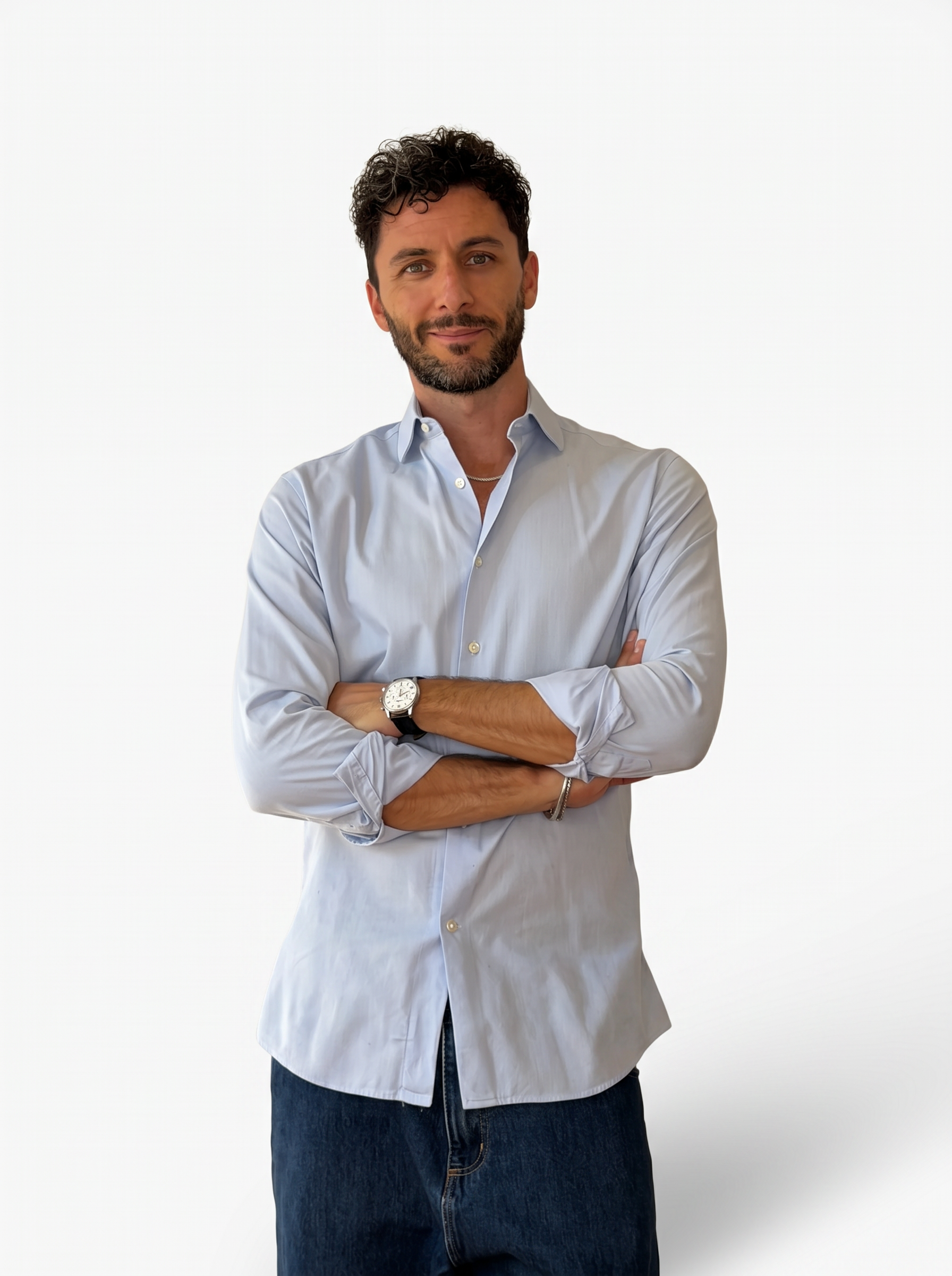 Matteo Mantovani in piedi, a braccia incrociate, davanti a una parete chiara